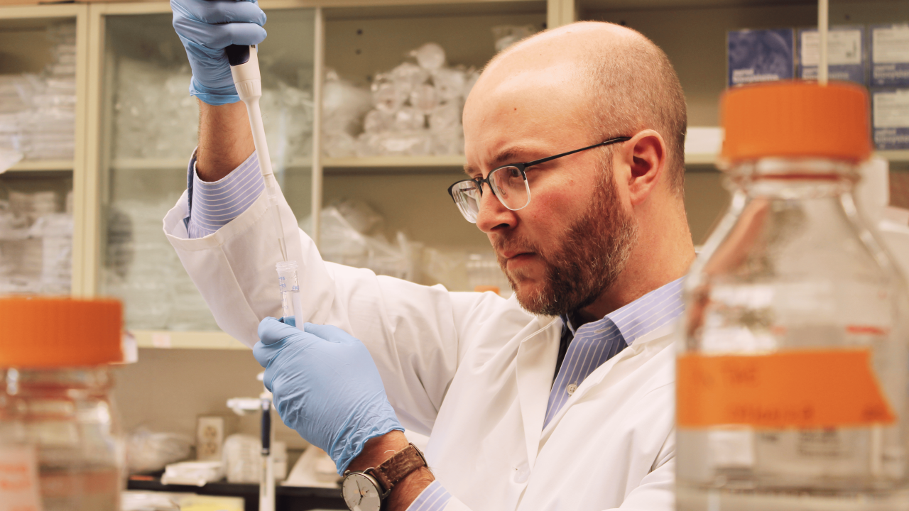 Dr. Mendel in the lab with a pipet